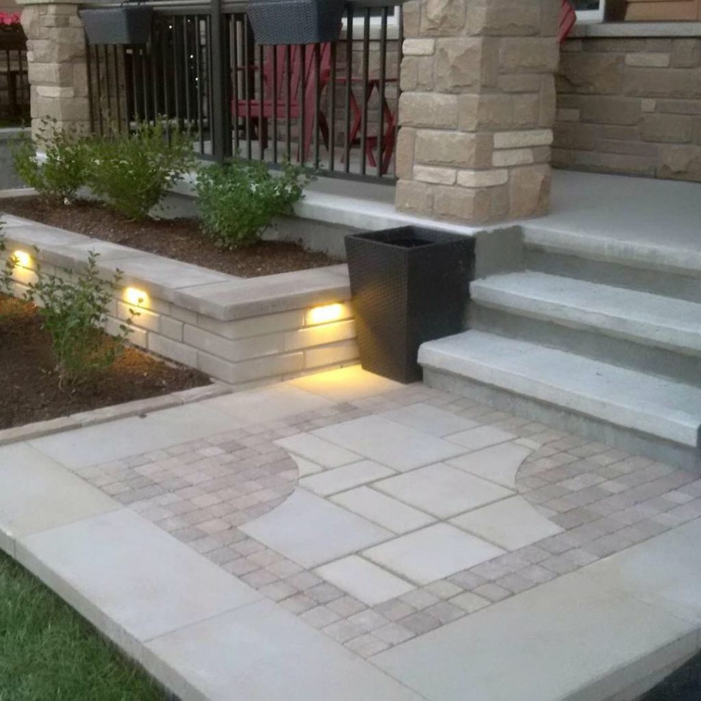 stone front porch with garden and lights
